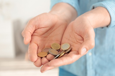 Photo of Man holding coins in hands indoors, closeup