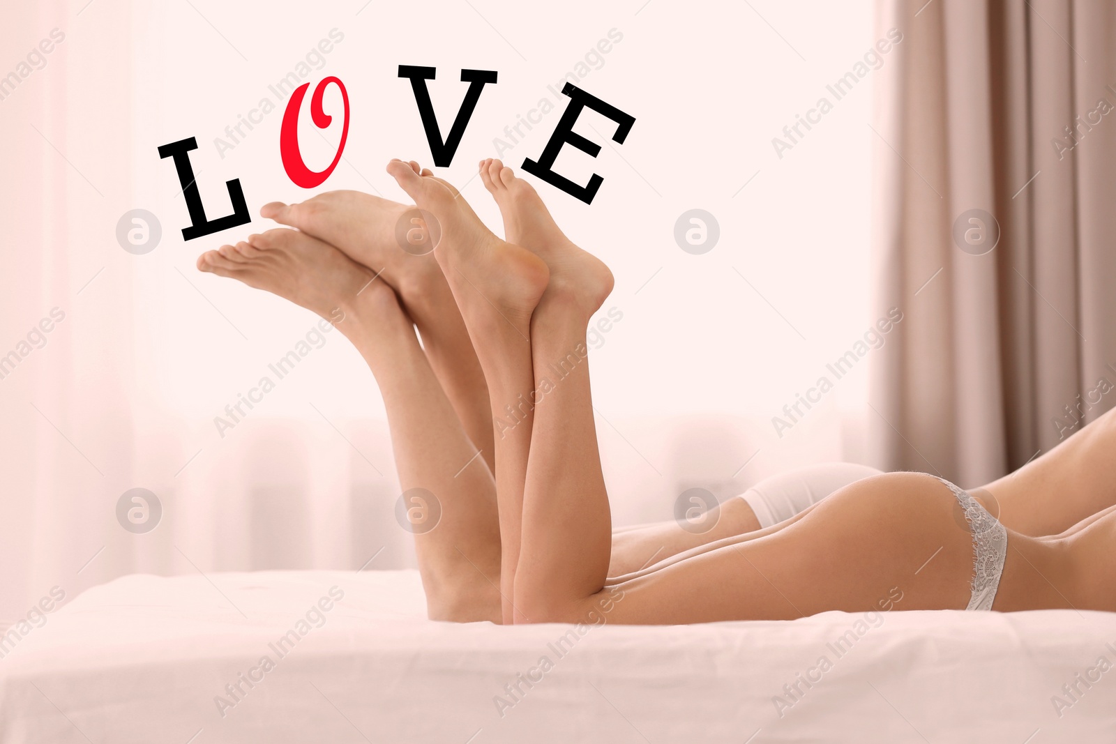 Image of Young couple lying on bed at home and word LOVE