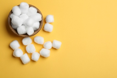 Photo of Bowl, fluffy cotton balls and space for text on color background, flat lay