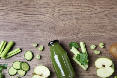 Photo of Glass bottle of celery juice and fresh ingredients on wooden table, flat lay. Space for text