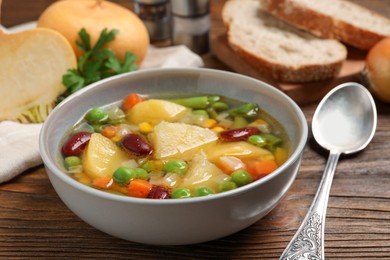 Photo of Bowl of delicious turnip soup served on wooden table