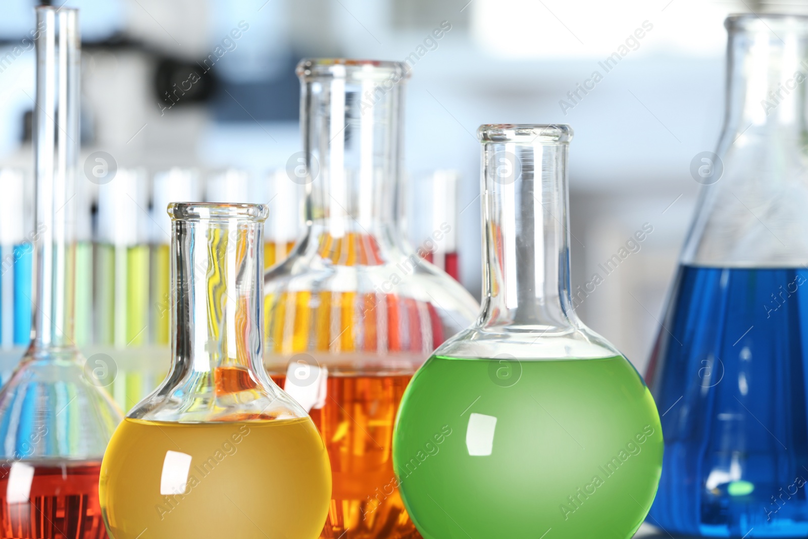 Photo of Glassware with different colorful liquids in laboratory