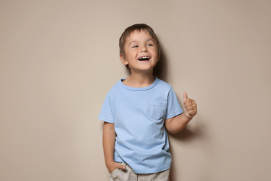 Photo of Portrait of cute little boy on beige background