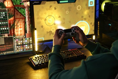 Man playing video games with controller at table indoors, closeup