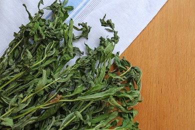 Photo of Bunches of wilted mint on wooden table, flat lay. Space for text