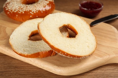 Photo of Delicious fresh bagels with sesame seeds on wooden table, closeup