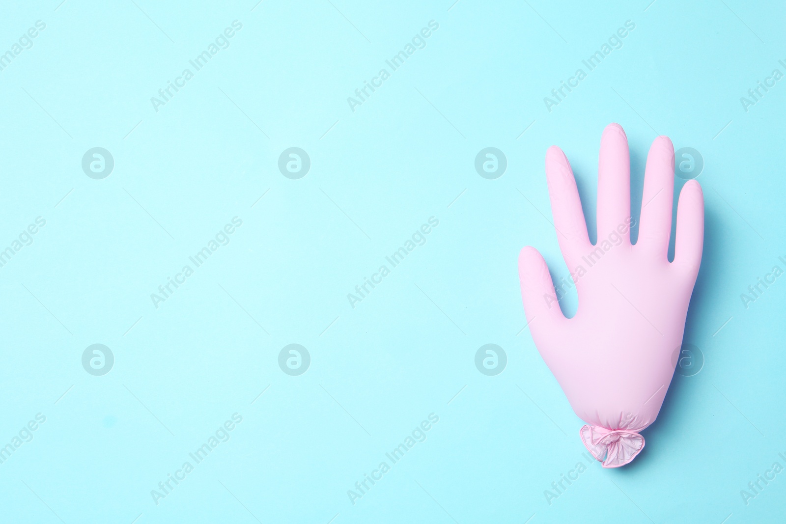 Photo of Inflated medical glove on color background, top view. Space for text