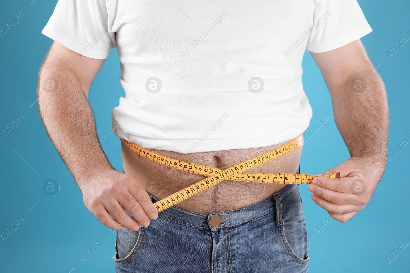 Photo of Overweight man with large belly and measuring tape on color background, closeup