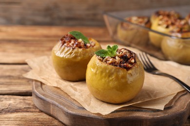 Tasty baked apples served on wooden table