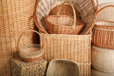 Photo of Many different wicker baskets made of natural material as background, closeup