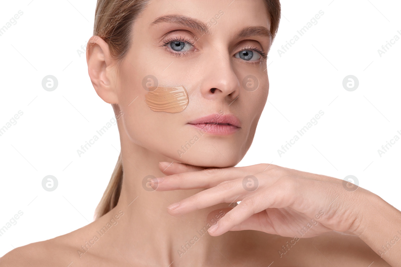 Photo of Woman with swatch of foundation on face against white background