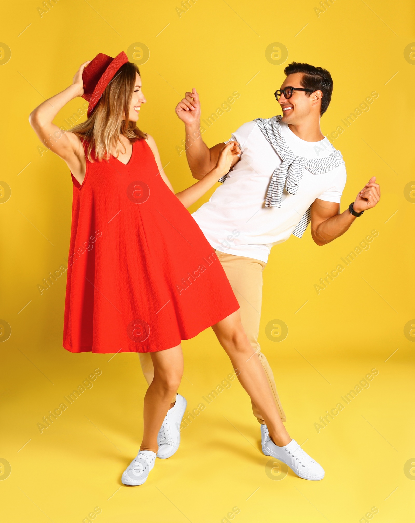 Photo of Beautiful young couple dancing on yellow background