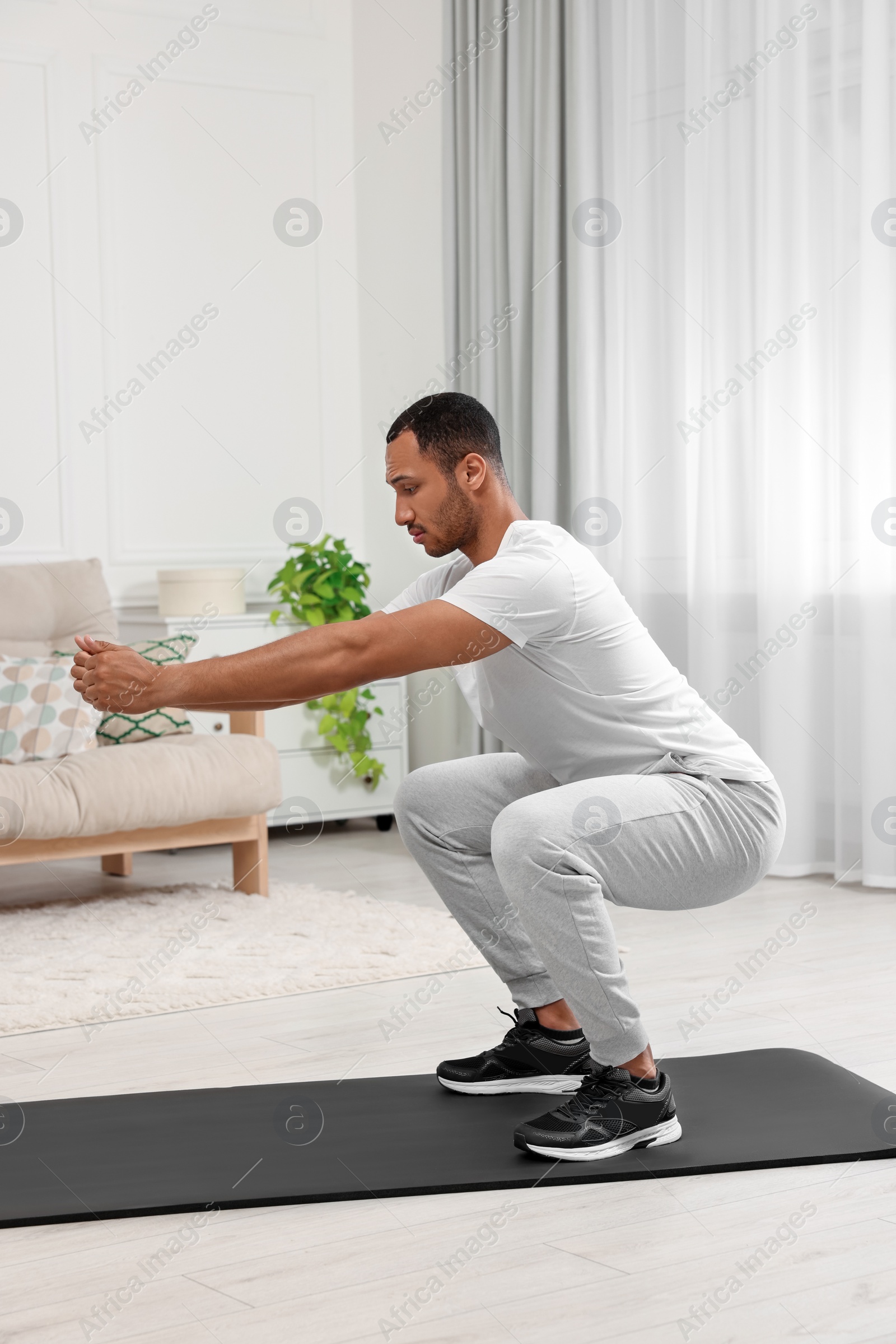 Photo of Man doing morning exercise on fitness mat at home