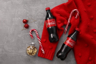 Photo of MYKOLAIV, UKRAINE - JANUARY 13, 2021: Flat lay composition with Coca-Cola bottles, Christmas decor and red sweater on floor