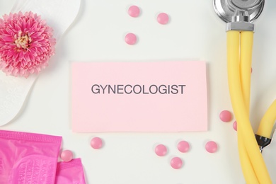 Photo of Flat lay composition with stethoscope, menstrual pads and pills on color background. Gynecological checkup