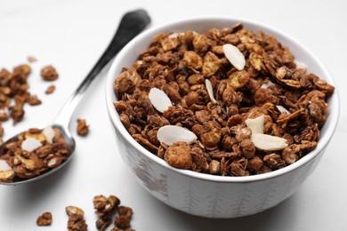 Bowl of tasty granola with nuts and dry fruits on white marble table