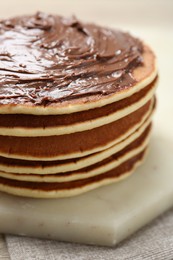 Photo of Delicious pancakes with chocolate paste on table, closeup