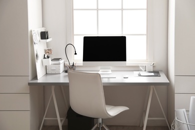 Photo of Light work place with computer near window. Interior design