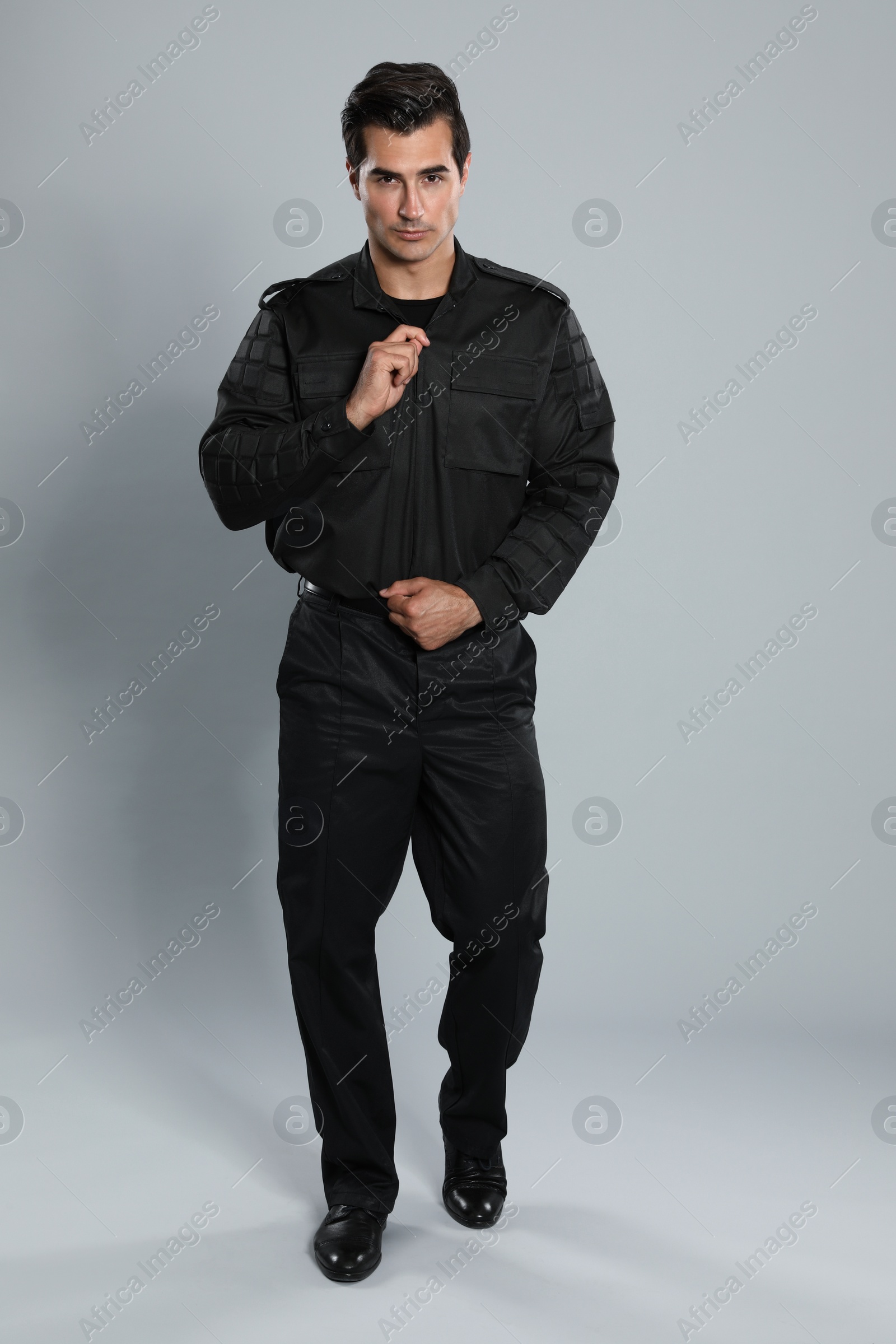 Photo of Male security guard in uniform on grey background