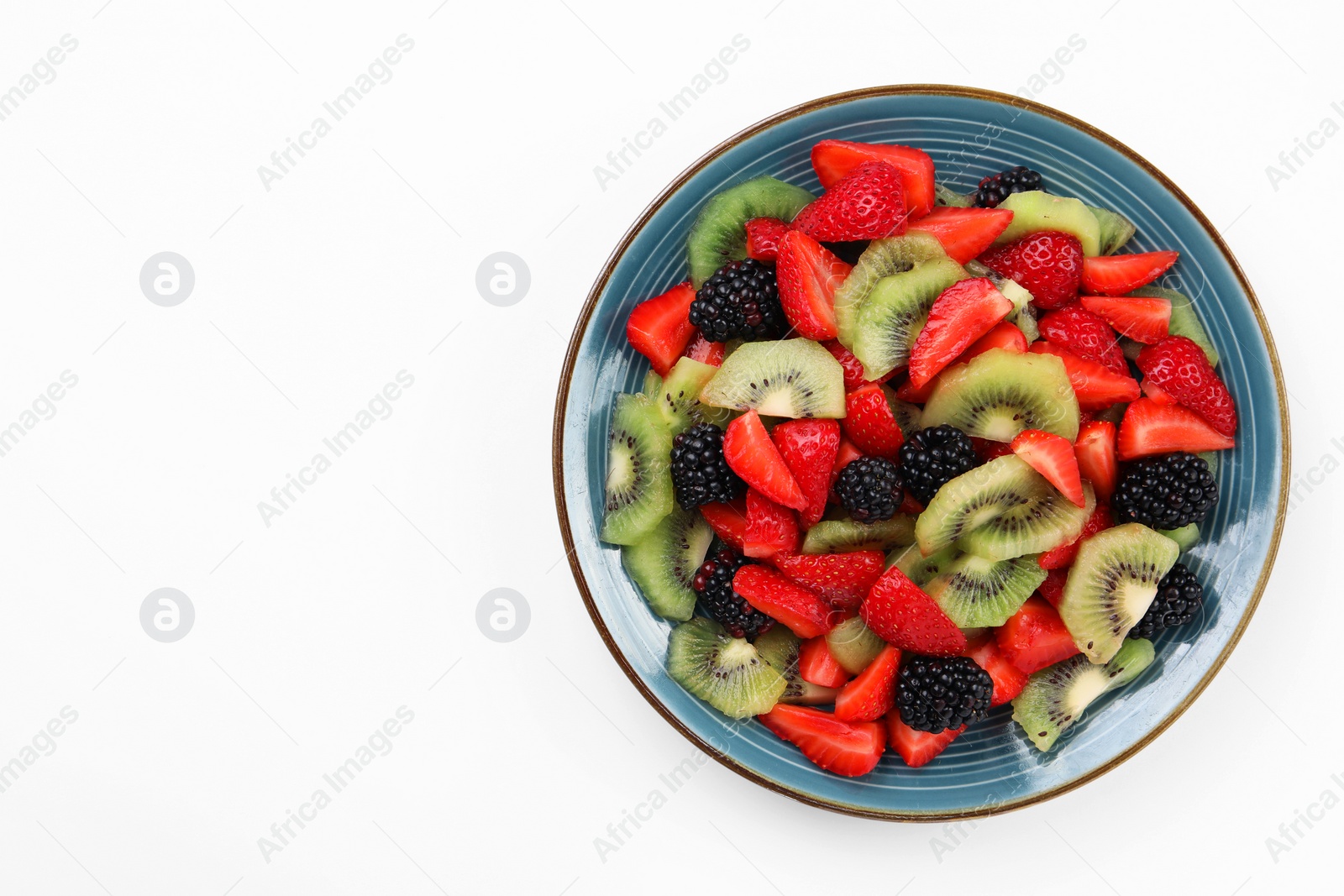 Photo of Plate of yummy fruit salad on white background, top view. Space for text