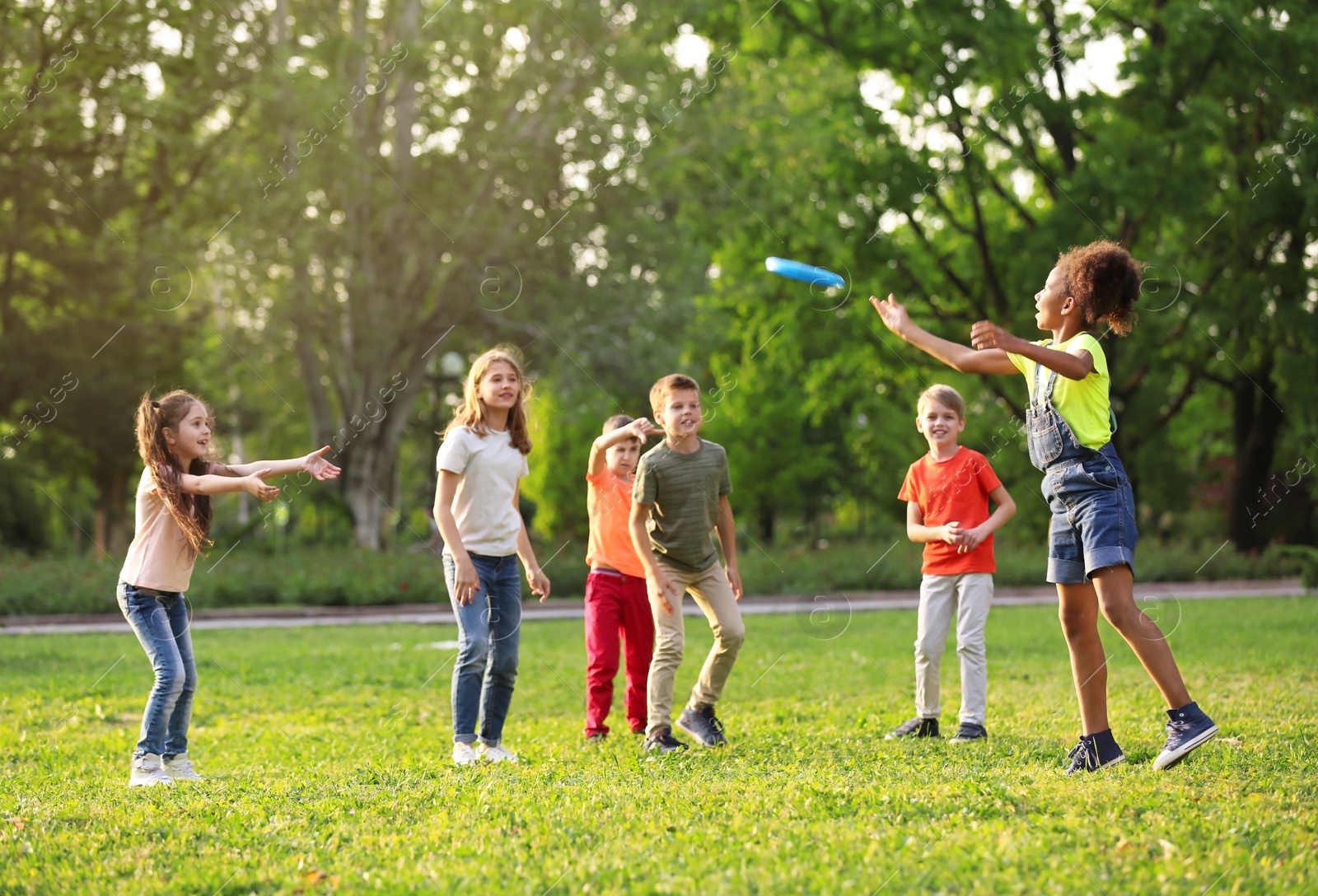 Photo of Cute little children playing with frisbee outdoors on sunny day