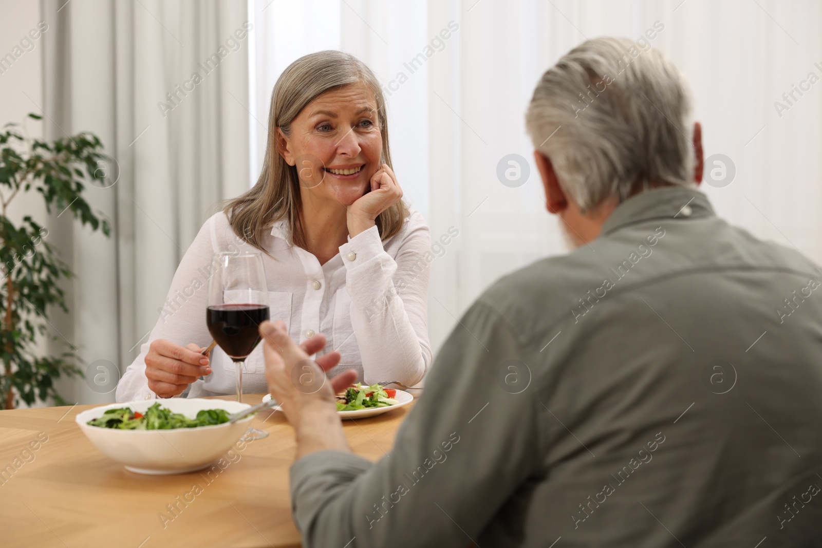 Photo of Happy senior couple having romantic dinner at home