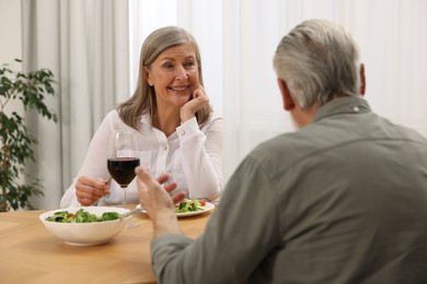 Happy senior couple having romantic dinner at home