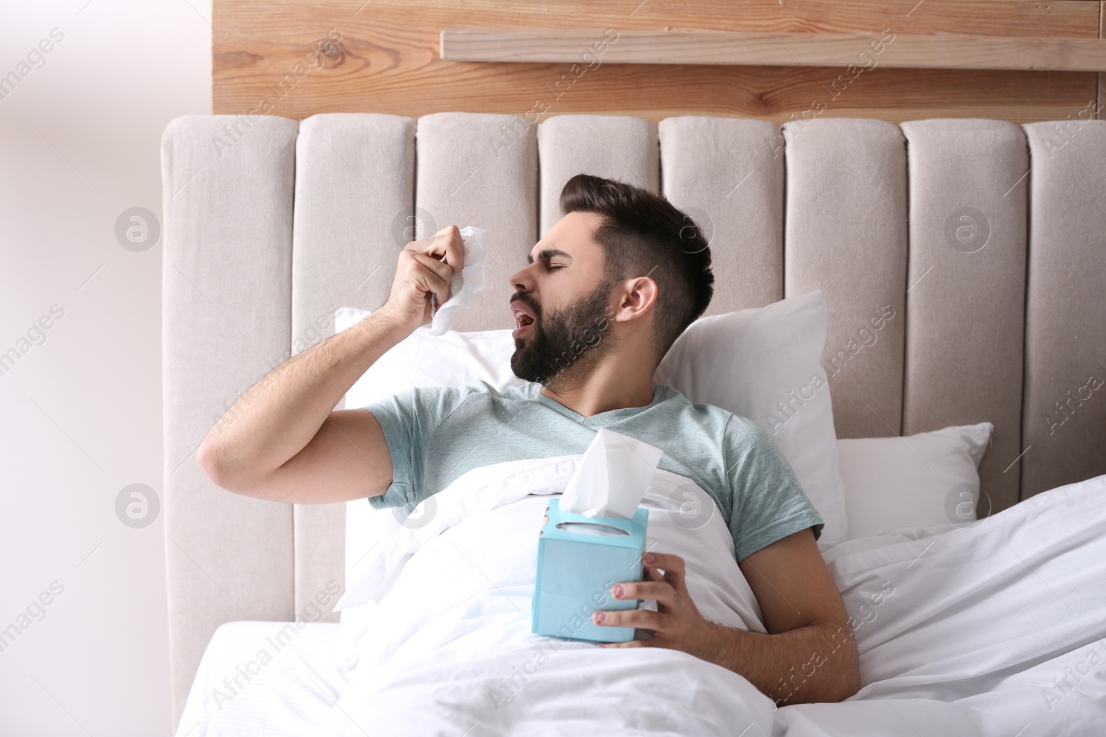 Photo of Man suffering from runny nose in bed