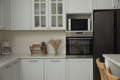 Modern microwave oven on shelf in kitchen