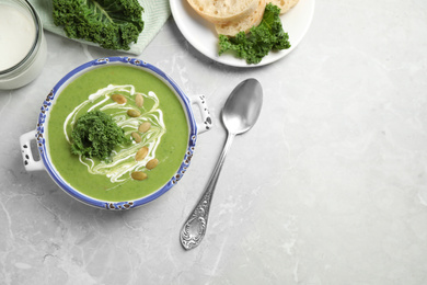 Photo of Tasty kale soup served on light grey marble table, flat lay. Space for text