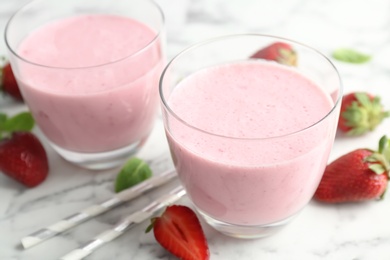 Glasses with healthy detox smoothie and strawberries on table