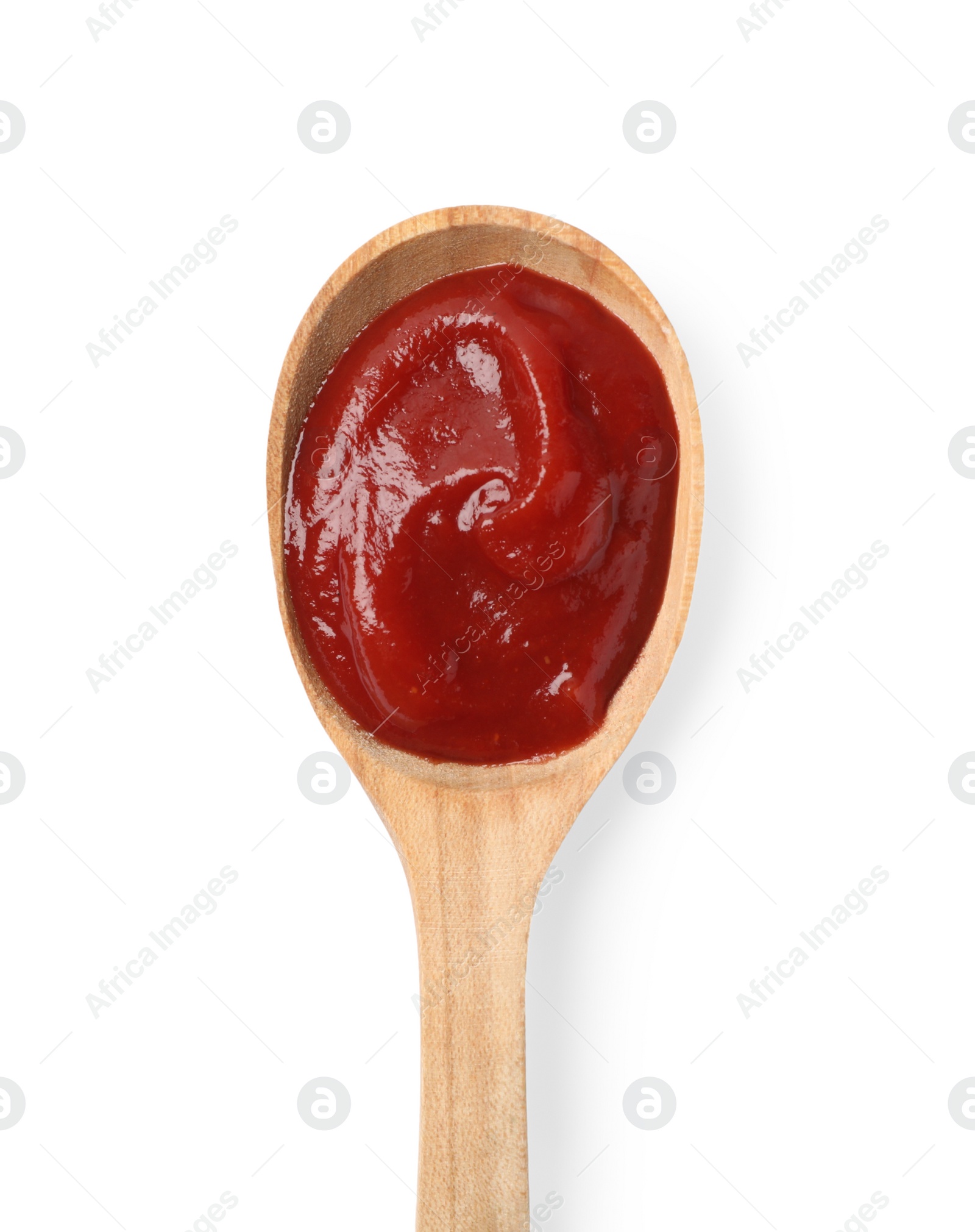 Photo of Ketchup in wooden spoon isolated on white, top view