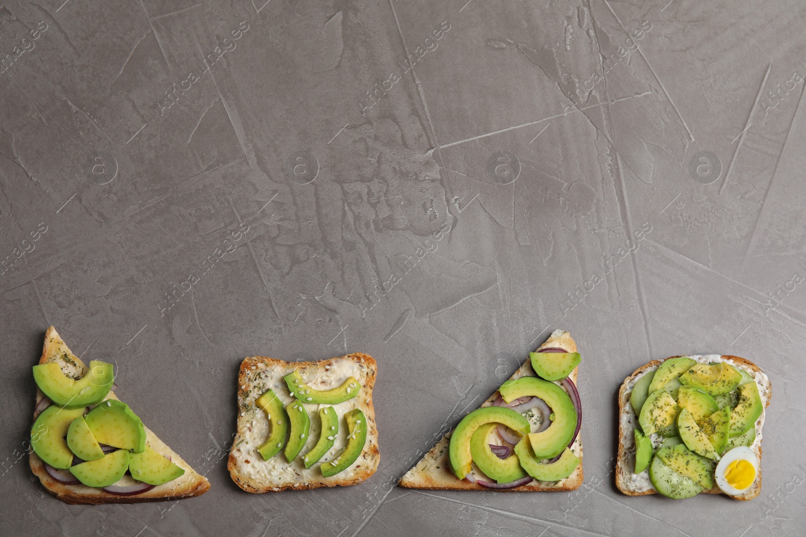 Photo of Tasty avocado toasts on grey table, flat lay. Space for text