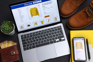 Photo of Online shopping. Composition with laptop on black background, above view