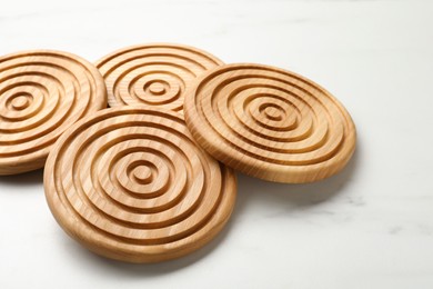 Stylish wooden cup coasters on white marble table