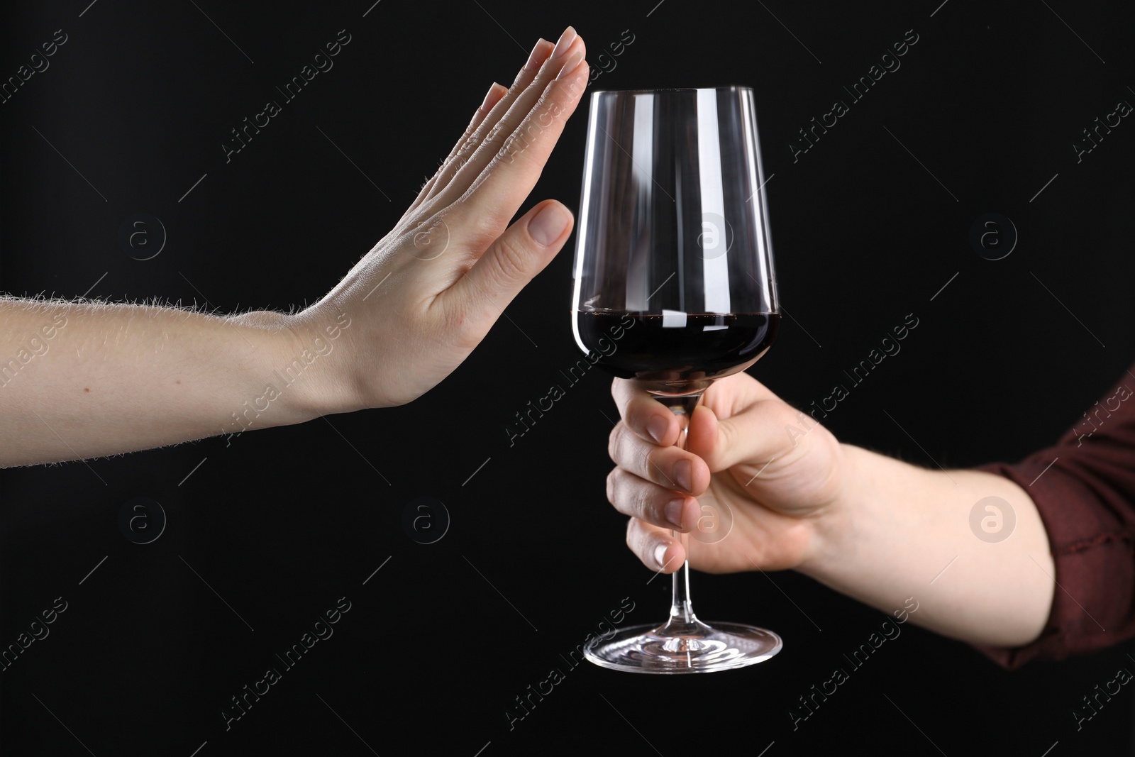 Photo of Alcohol addiction. Woman refusing glass of wine on black background, closeup