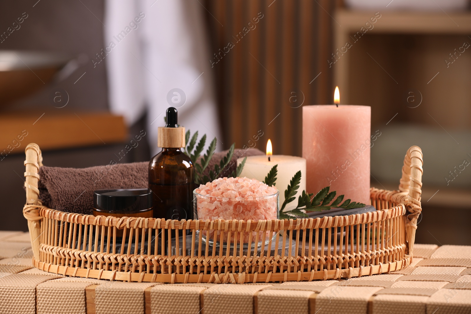 Photo of Beautiful composition with different spa products on wicker bench indoors