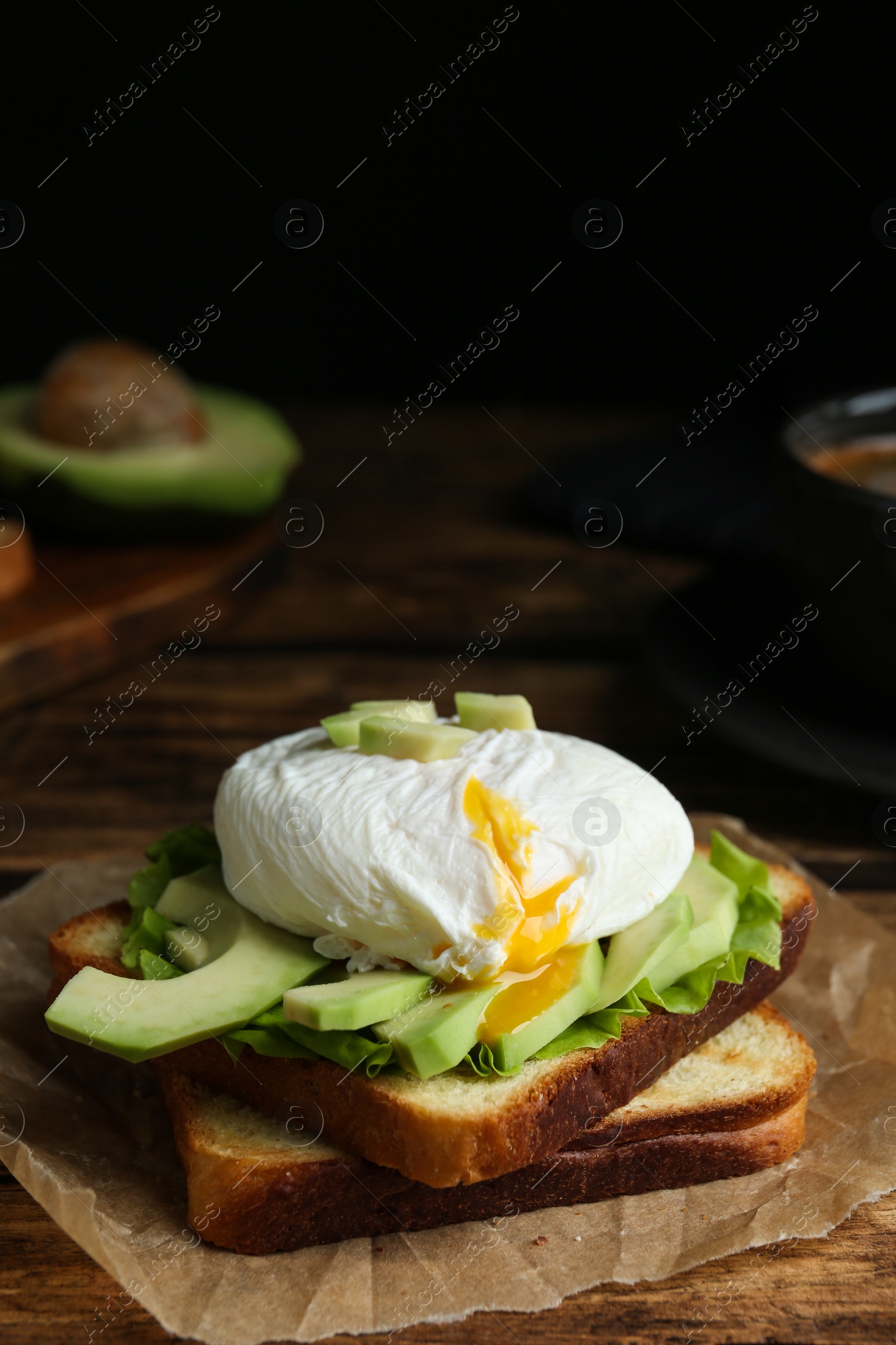 Photo of Delicious poached egg sandwich served on wooden table