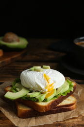 Delicious poached egg sandwich served on wooden table