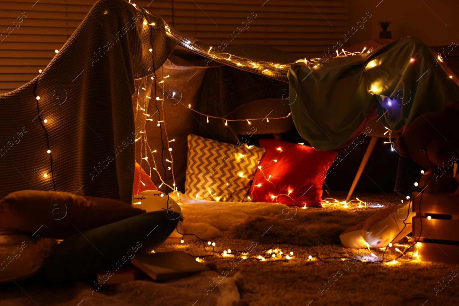 Photo of Beautiful play tent decorated with festive lights at home