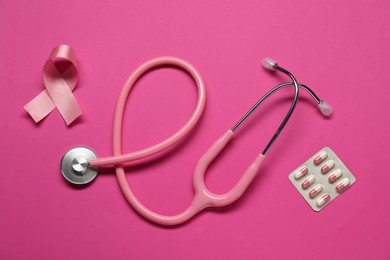 Pink ribbon, stethoscope and pills on color background, flat lay. Breast cancer awareness