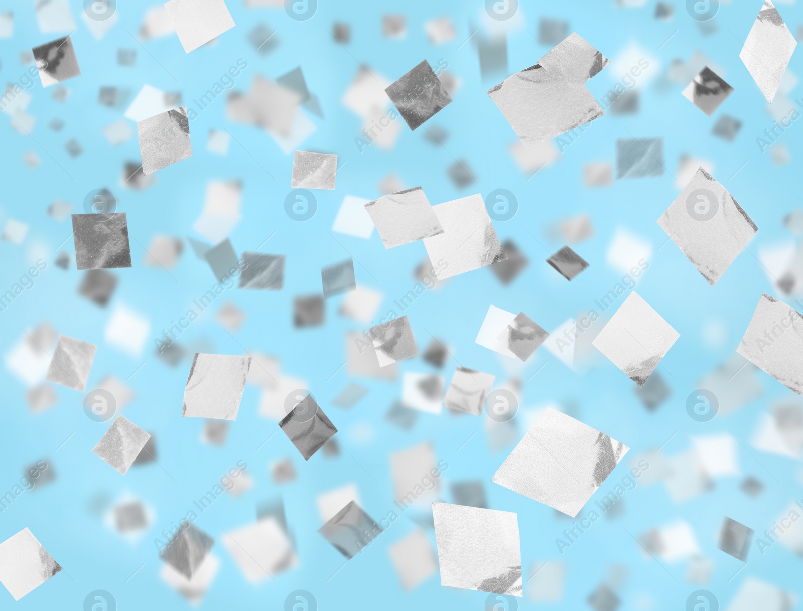 Image of White confetti falling down on light blue background