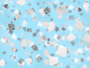 Image of White confetti falling down on light blue background