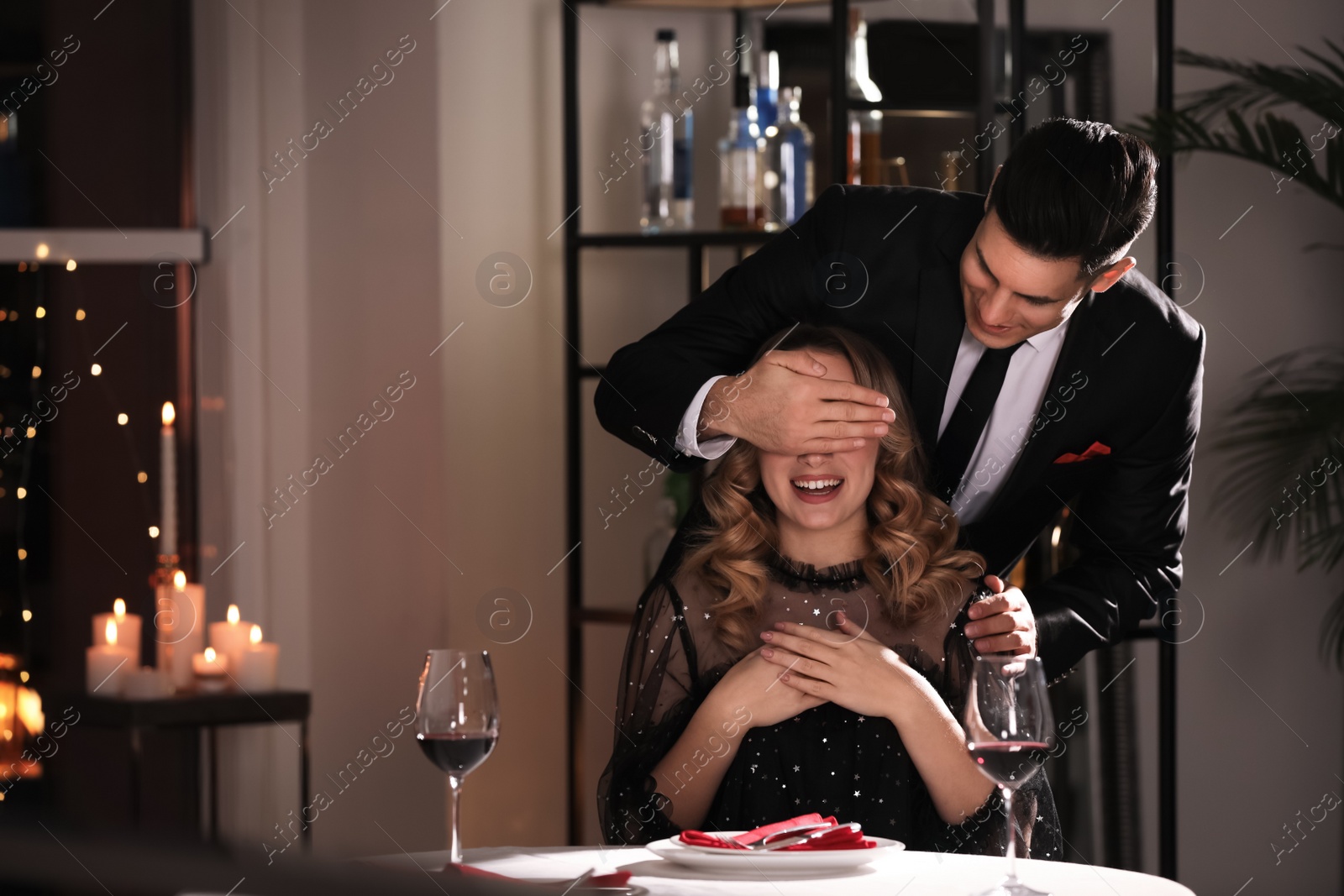 Photo of Man surprising his girlfriend in restaurant at Valentine's day dinner