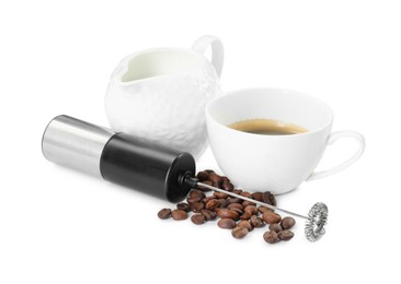 Photo of Mini mixer (milk frother), cup, coffee beans and pitcher isolated on white