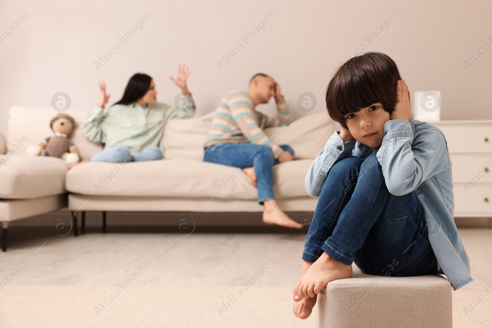 Photo of Couple arguing at home, focus on their upset child