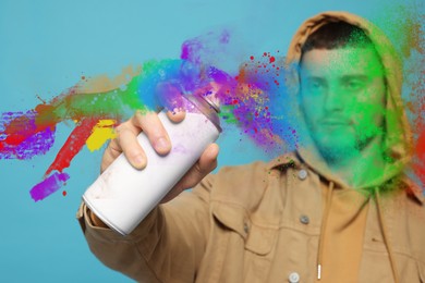 Image of Handsome man spaying paint against light blue background