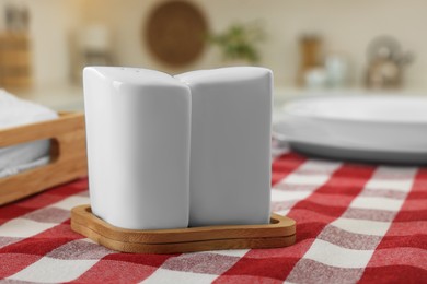 Photo of Ceramic salt and pepper shakers on kitchen table, closeup