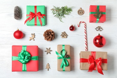 Photo of Flat lay composition with Christmas gift boxes on white wooden background