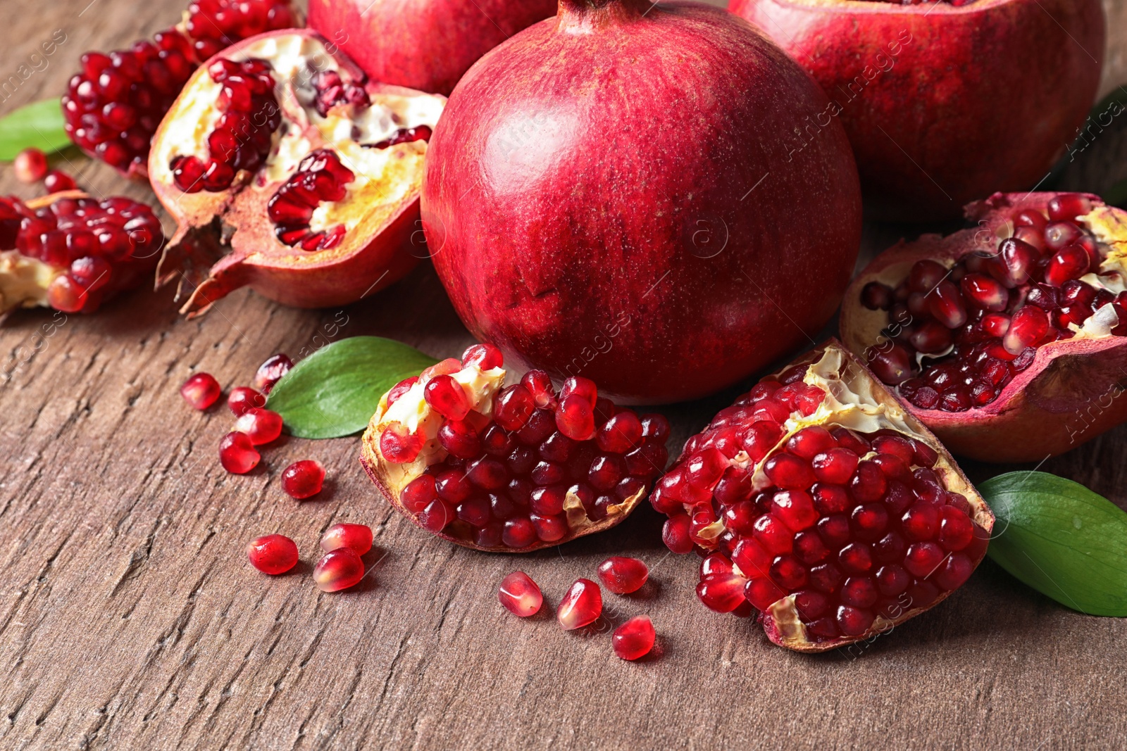 Photo of Composition with ripe pomegranates and leaves on color background